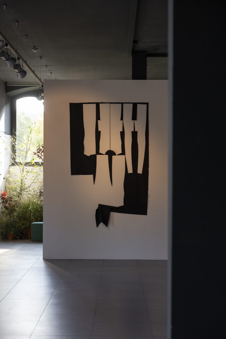 Imaginarium 2022 exhibition space with a black abstract artwork on a white panel.