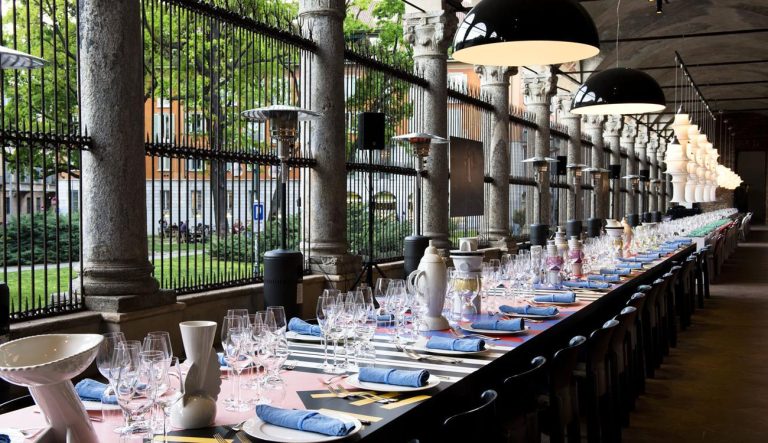 Interni 60th anniversary table setting: long dinner table laid under a colonnade