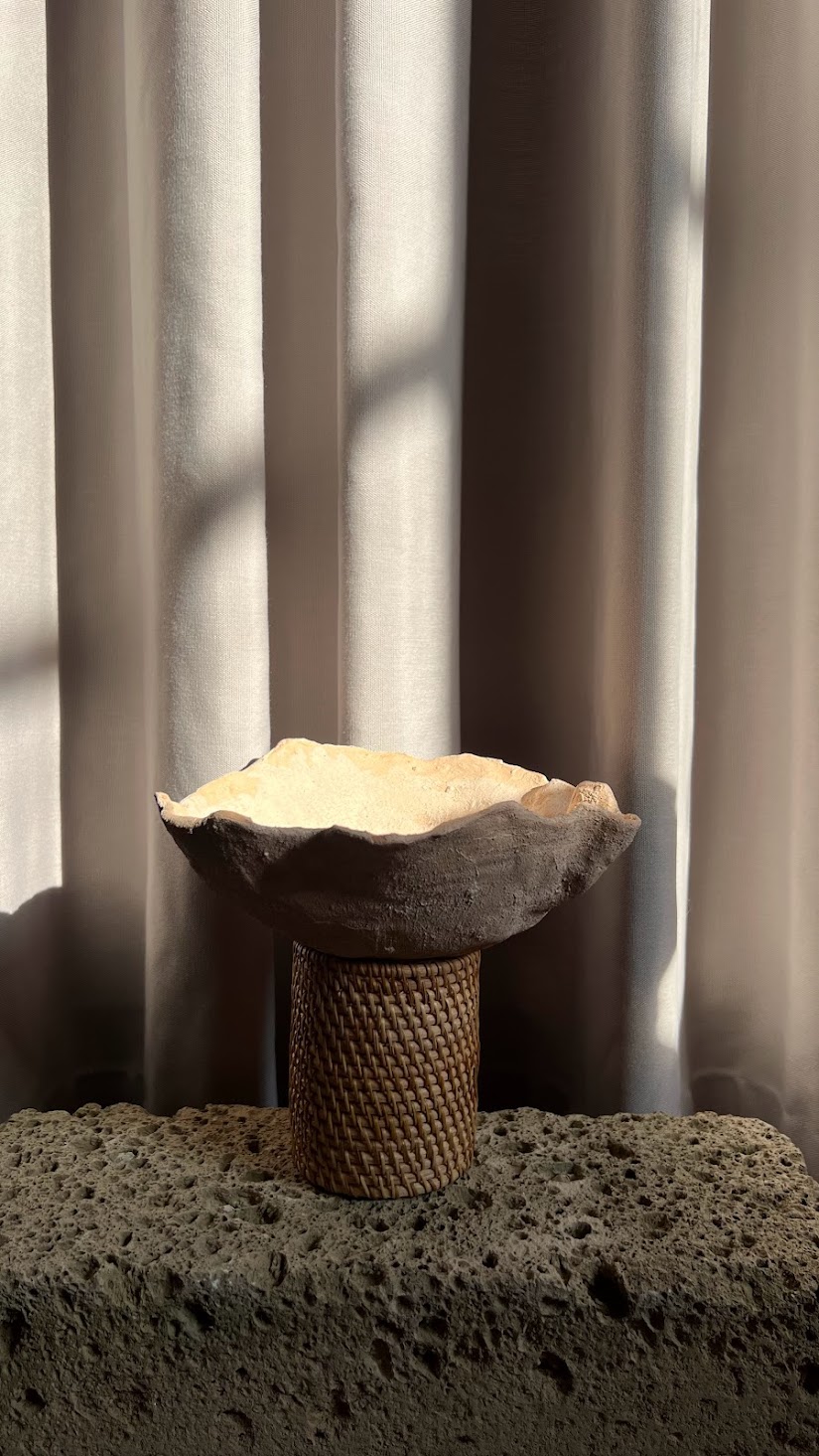 Dare forma alla terra, Santorini: wavy-rimmed ceramic bowl on a textured cylinder base on volcanic stone