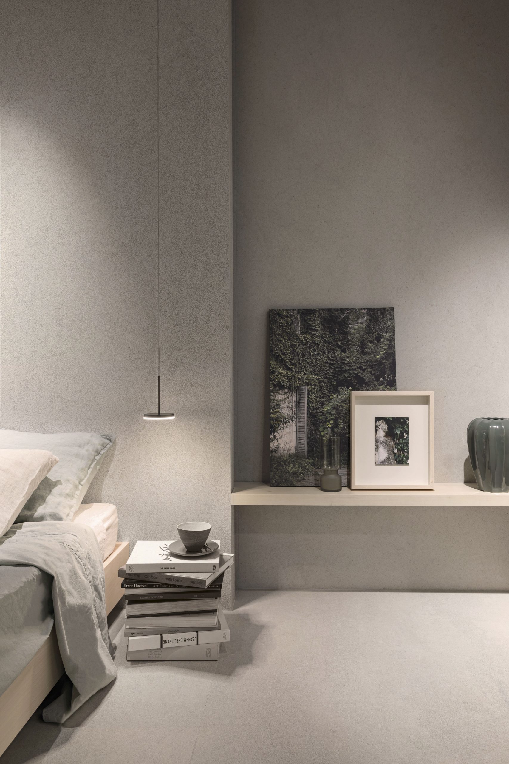 Suite The Secret Garden per Florim: camera con pareti in gres effetto pietra, lampada a sospensione e opere alle pareti