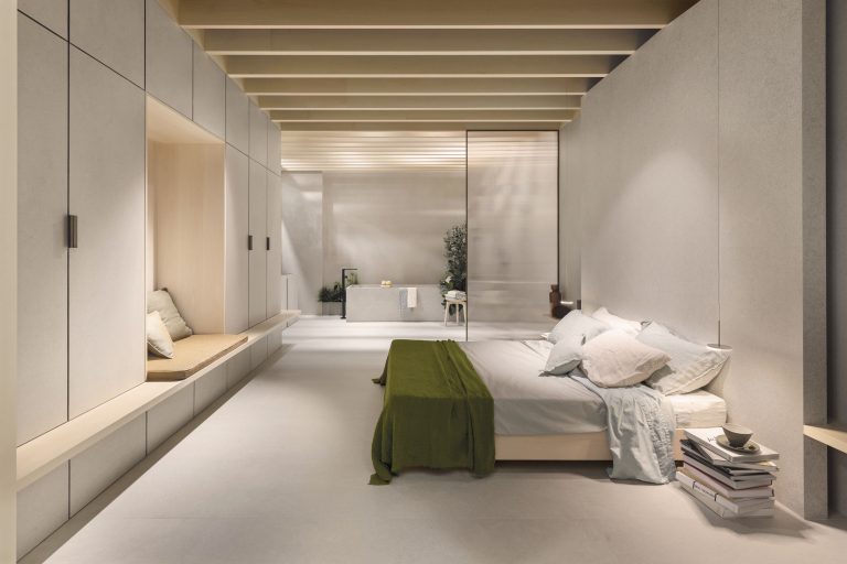 The Secret Garden suite for Florim: long bedroom with built-in wall units and a timber-beamed ceiling.