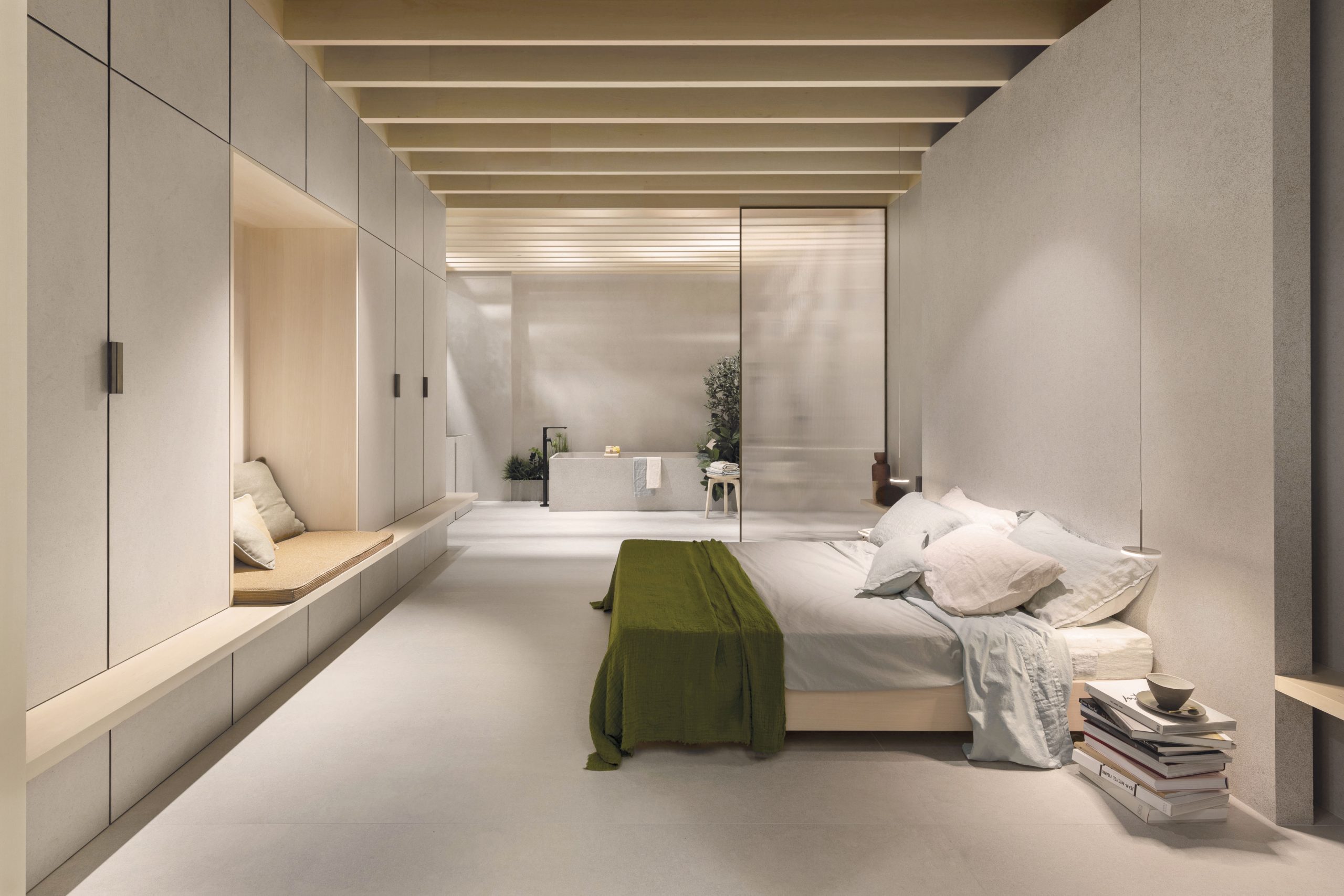 The Secret Garden suite for Florim: long bedroom with built-in wall units and a timber-beamed ceiling.