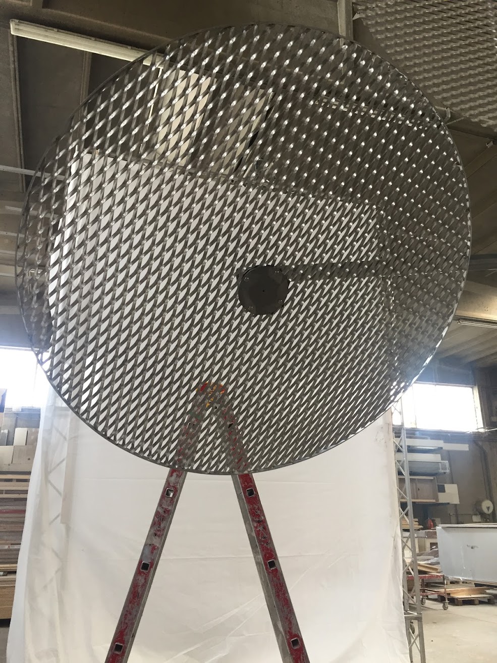 Milano Design Week installation for Zara: perforated metal disc on a stand during assembly