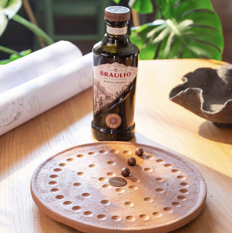 L'essenza del tempo for Braulio: Braulio bottle beside the terracotta disc with dark beads