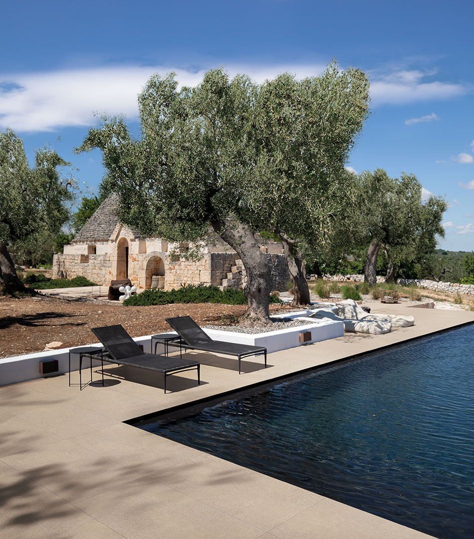 Sensi Collection by Florim: poolside terrace with olive trees and a stone trullo