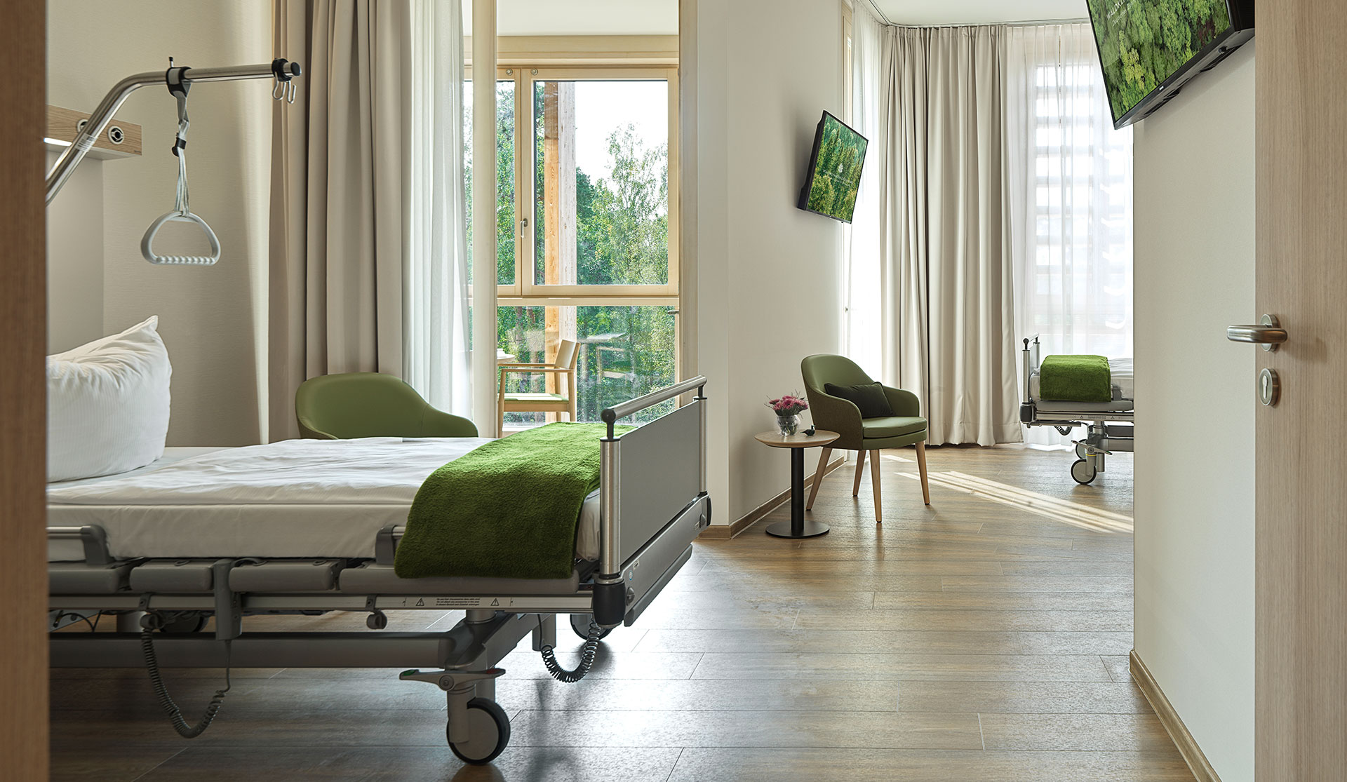 Waldkliniken Eisenberg: patient room with a hospital bed, green throw and wooden floor