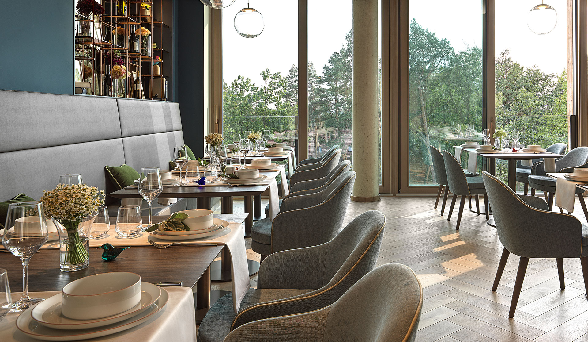 Waldkliniken Eisenberg: restaurant with grey upholstered chairs and a long banquette