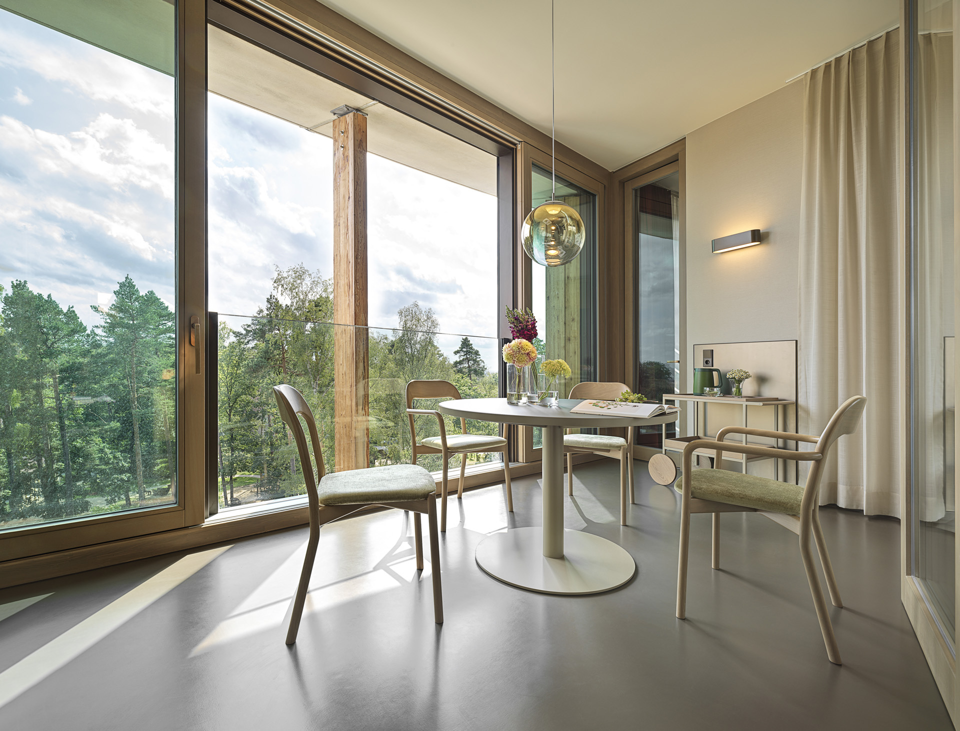 Waldkliniken Eisenberg: room with floor-to-ceiling windows onto the forest and a round table