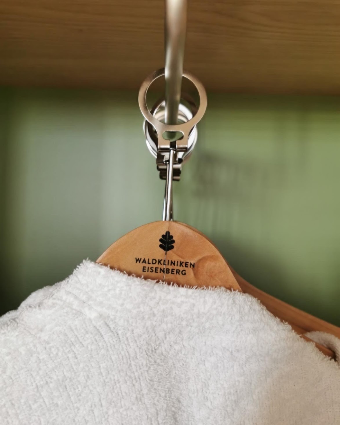 Waldkliniken Eisenberg: towelling robe on a wooden hanger with the clinic's logo