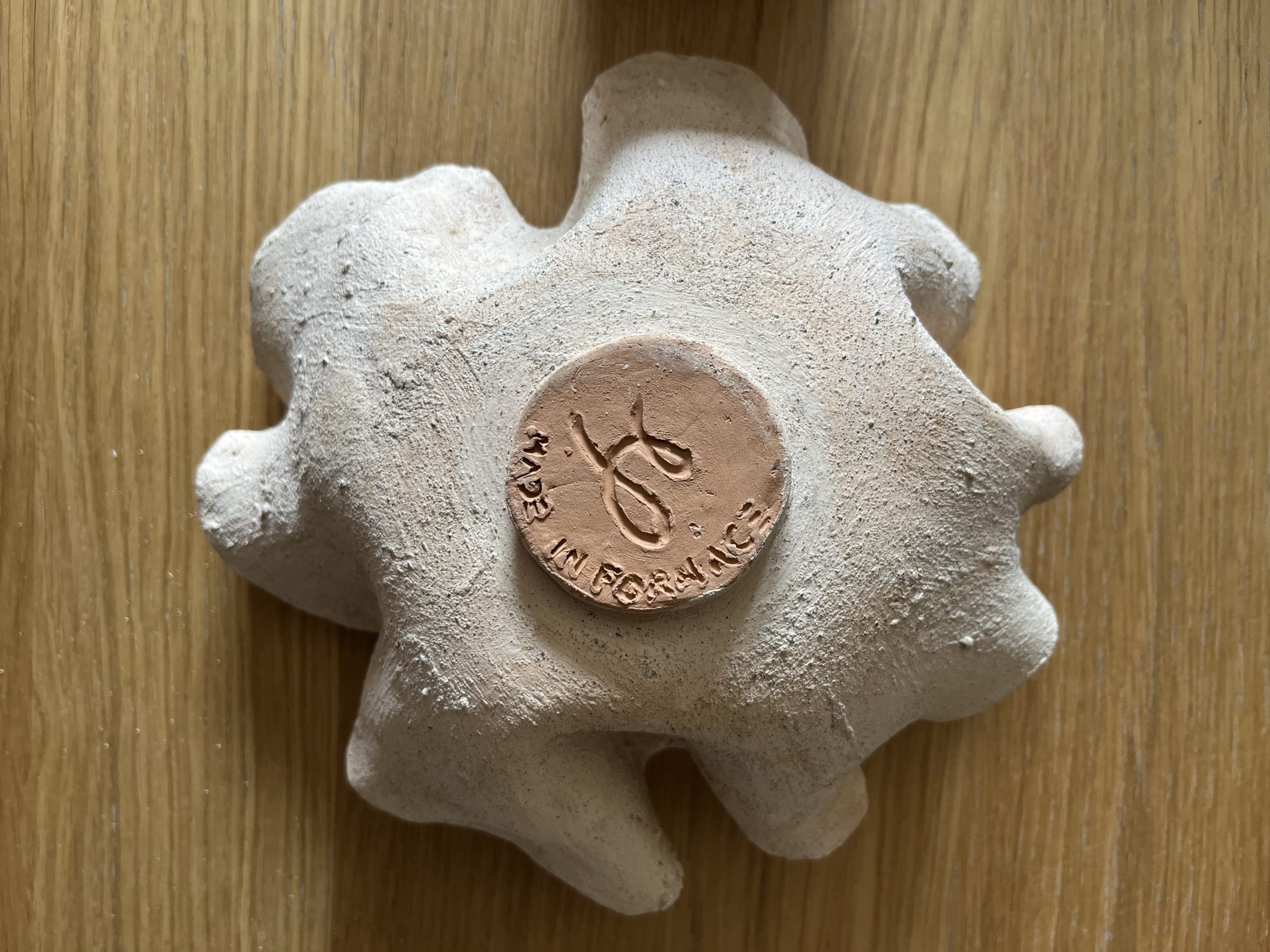 Dare forma alla terra, Santorini: underside of an irregular ceramic dish with a round stamp