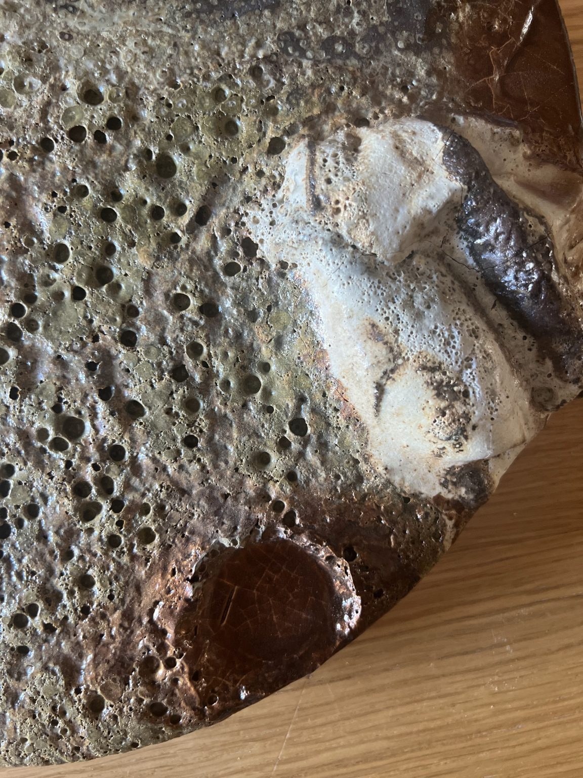 Melting Pot, Land: close-up of pitted ceramic with fused white fragments