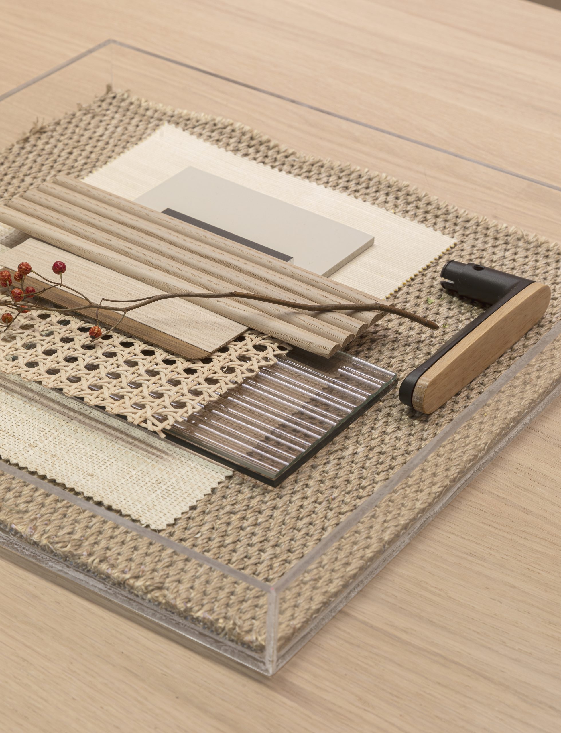 Material board for the Effebiquattro brand image: wood samples, cane, fabrics and a handle in an acrylic tray.