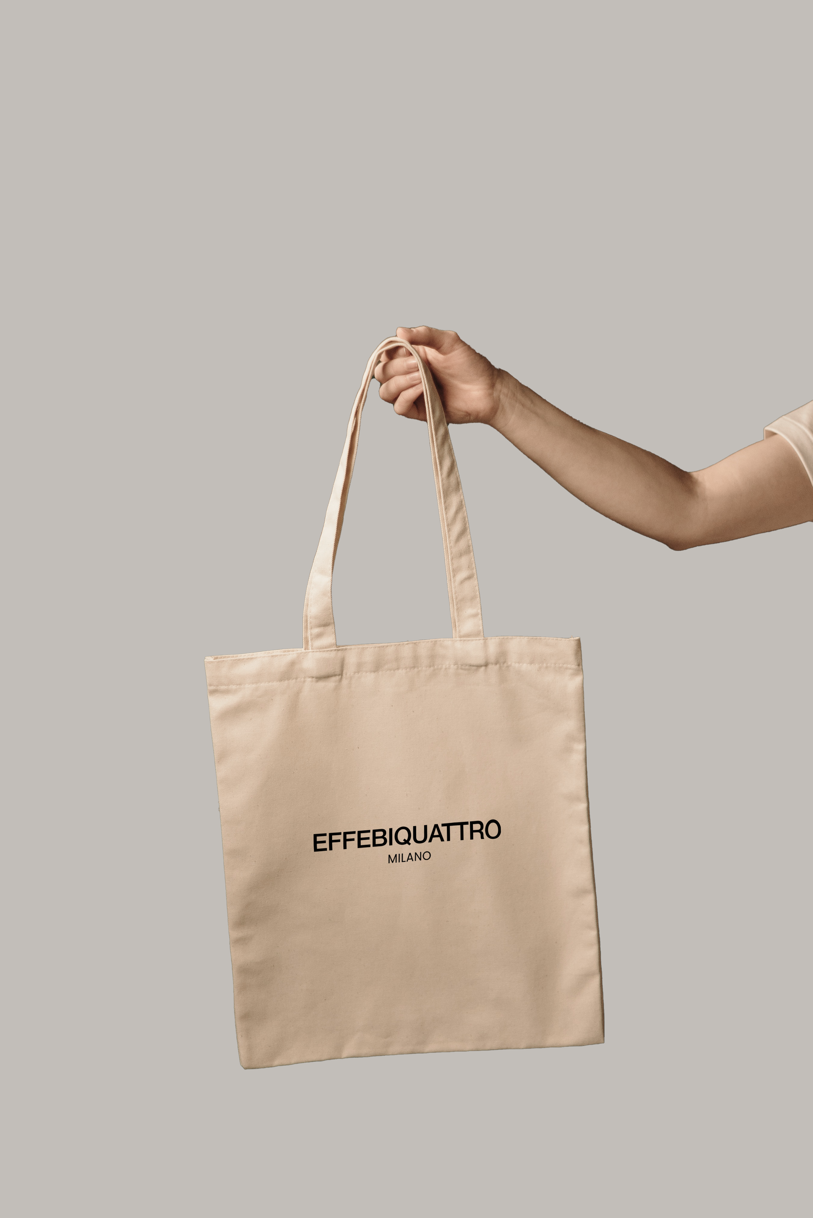 Effebiquattro Milano brand image: hand holding a canvas tote bag with the new logo