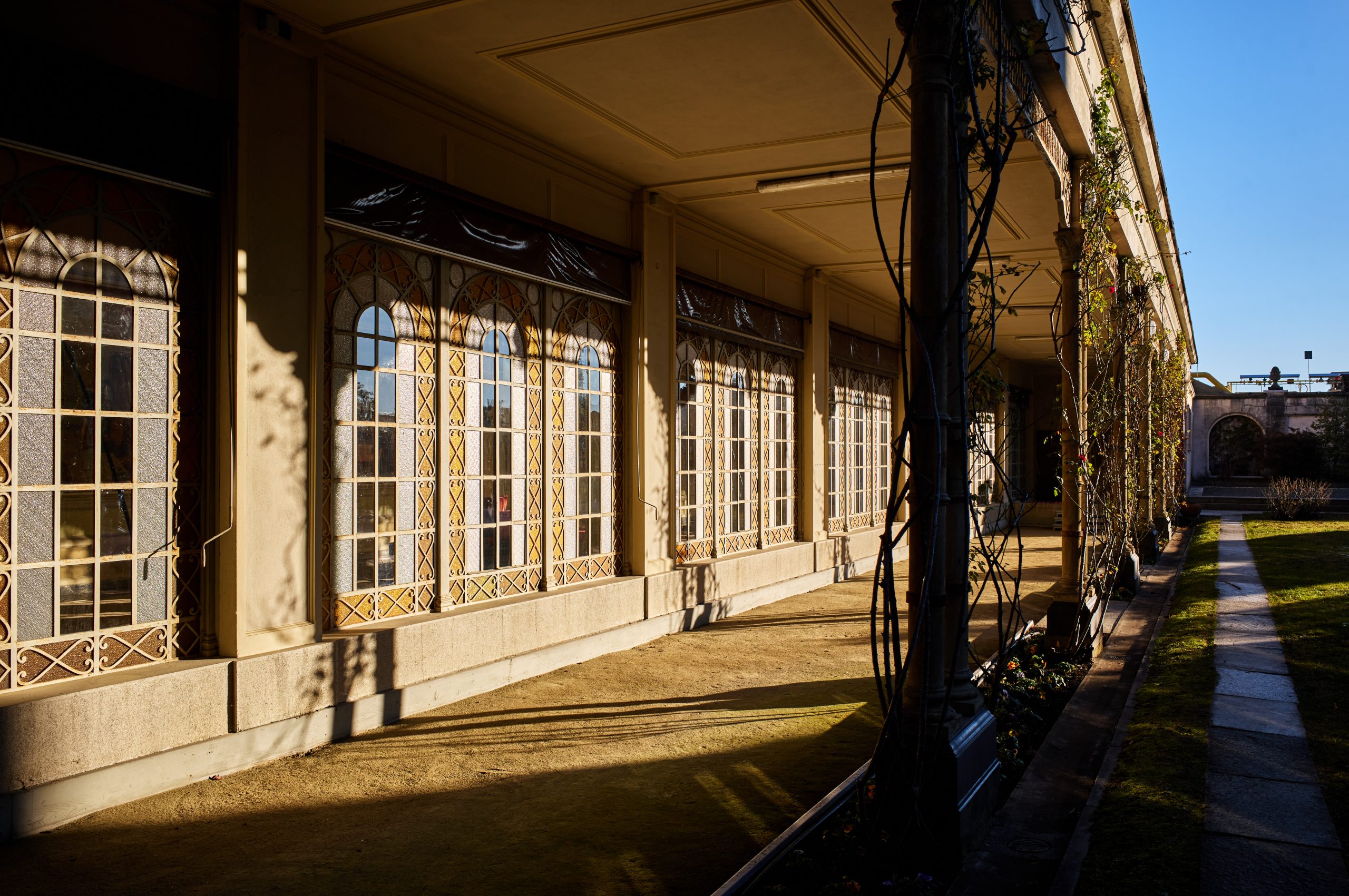 Sunlit loggia beside the Sala quadri at Fondazione Zegna, with tall windows along the facade.
