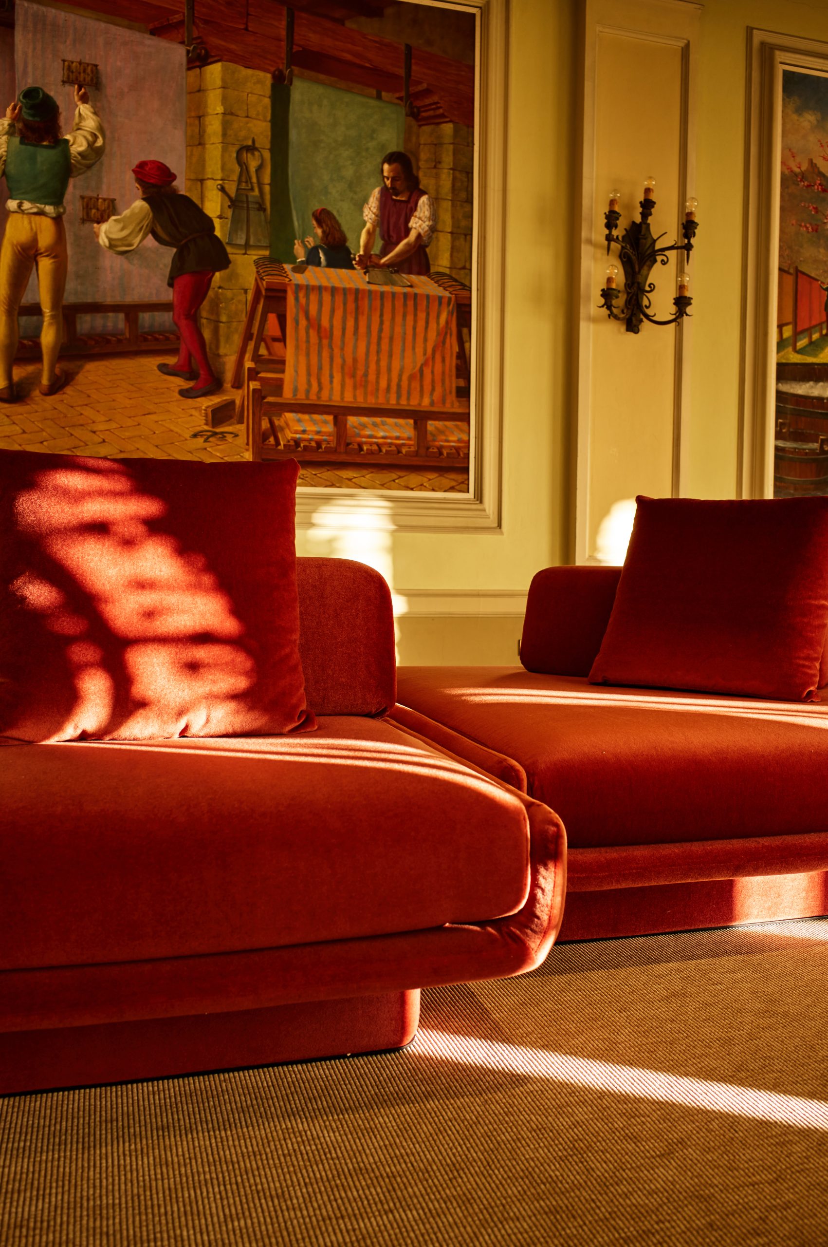 Rust velvet sofa beneath a large painted panel in the Sala quadri at Fondazione Zegna.