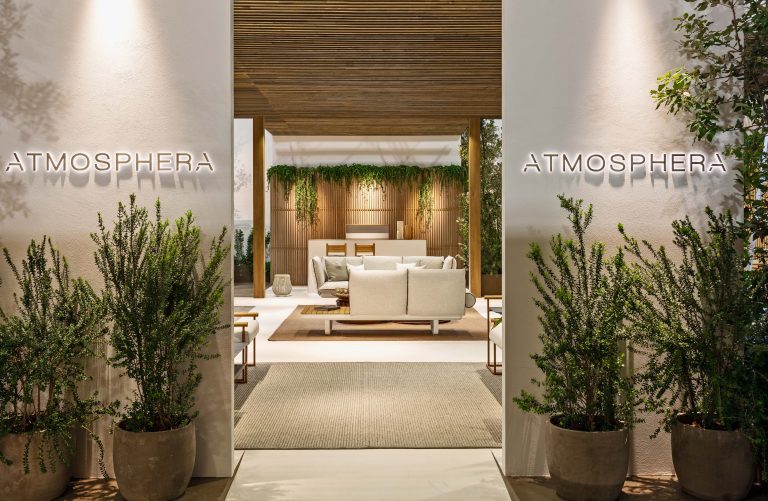 Entrance to the Atmosphera booth at Salone del Mobile 2024, with olive trees and outdoor sofas, designed by Elena Pelosi.