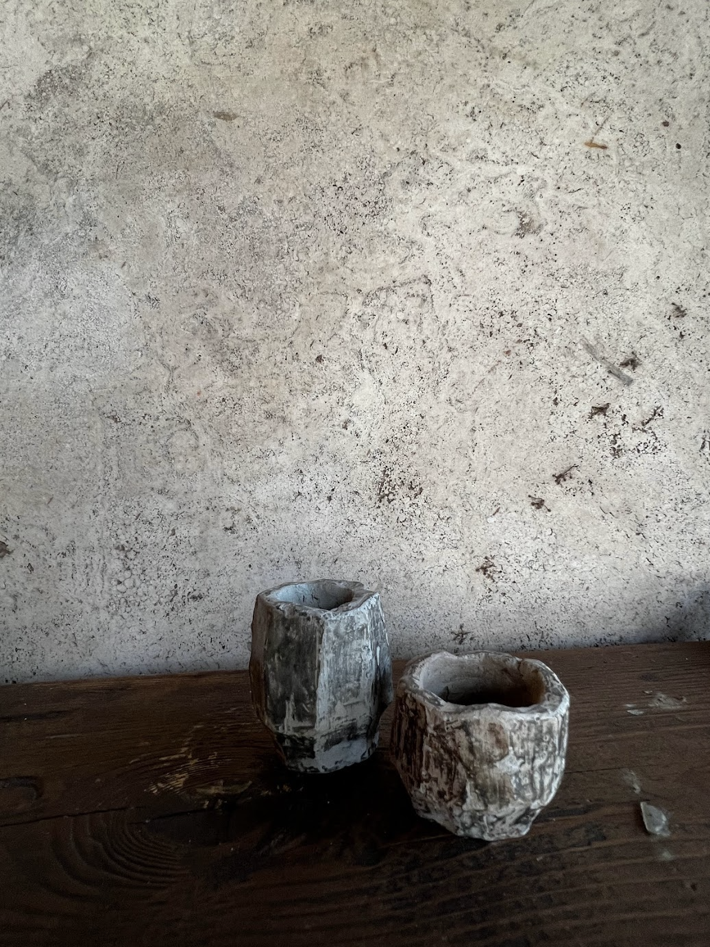 Elena Pelosi Studio: due vasi in ceramica grezza contro un muro di pietra