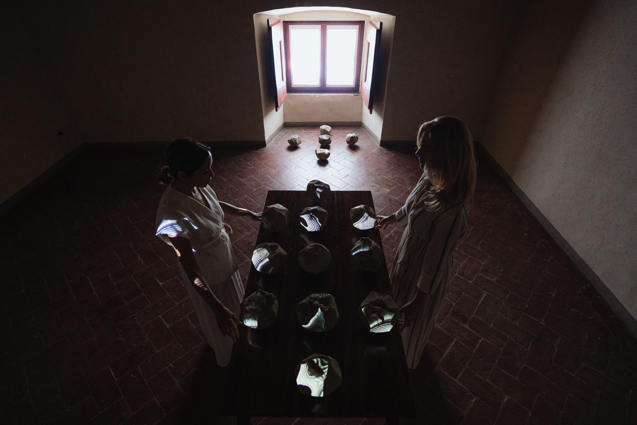 Performance Portal of Memory, Villa Ferdinanda: due performer a un tavolo di pietre in ceramica sotto una finestra