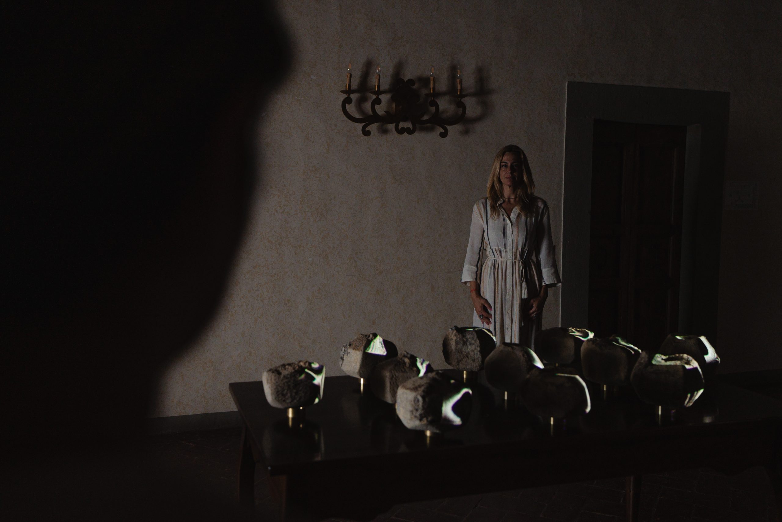 Portal of Memory performance, Villa Ferdinanda: figure standing behind a field of ceramic stones