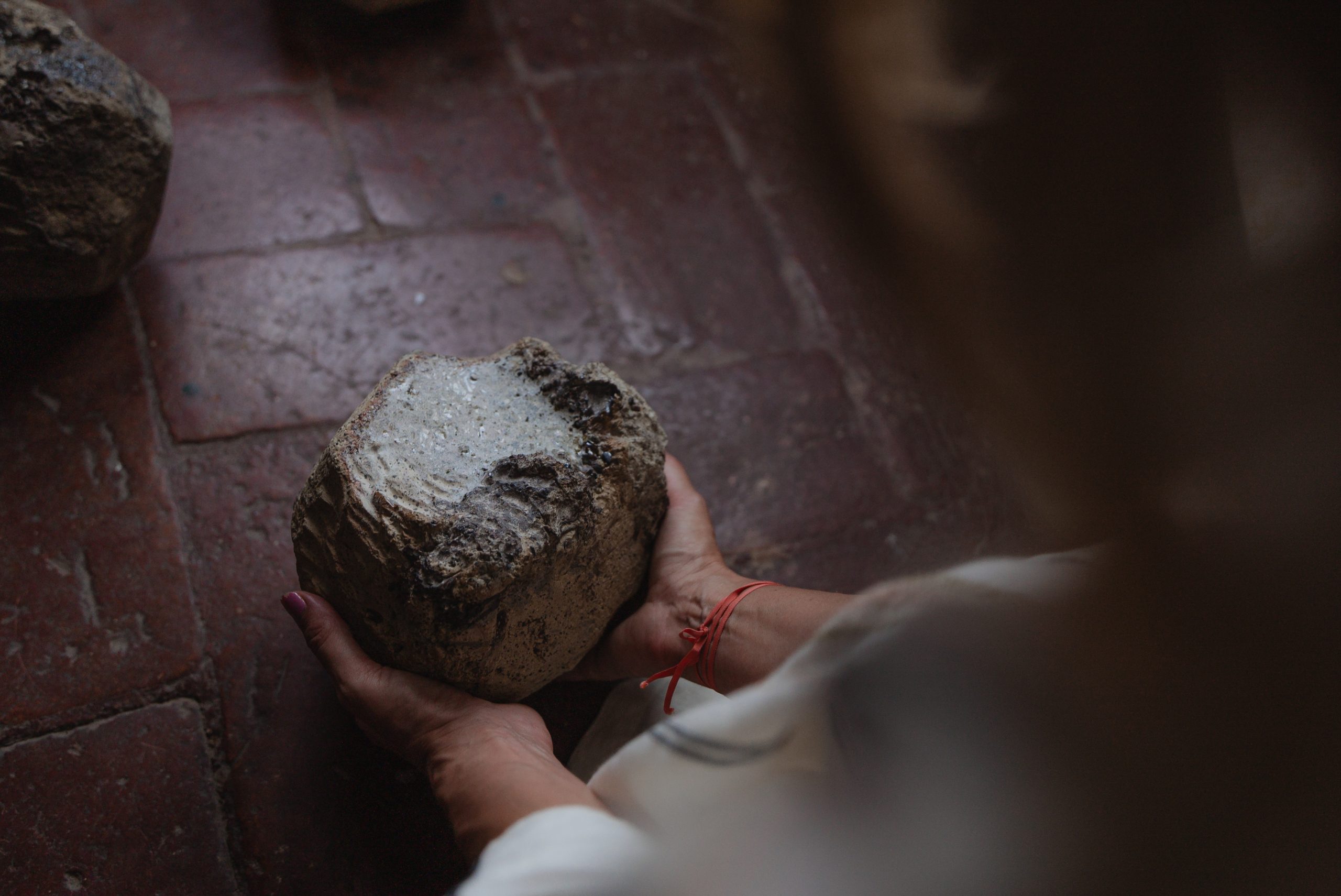 Performance Portal of Memory, Villa Ferdinanda: mani che sollevano una pietra in ceramica