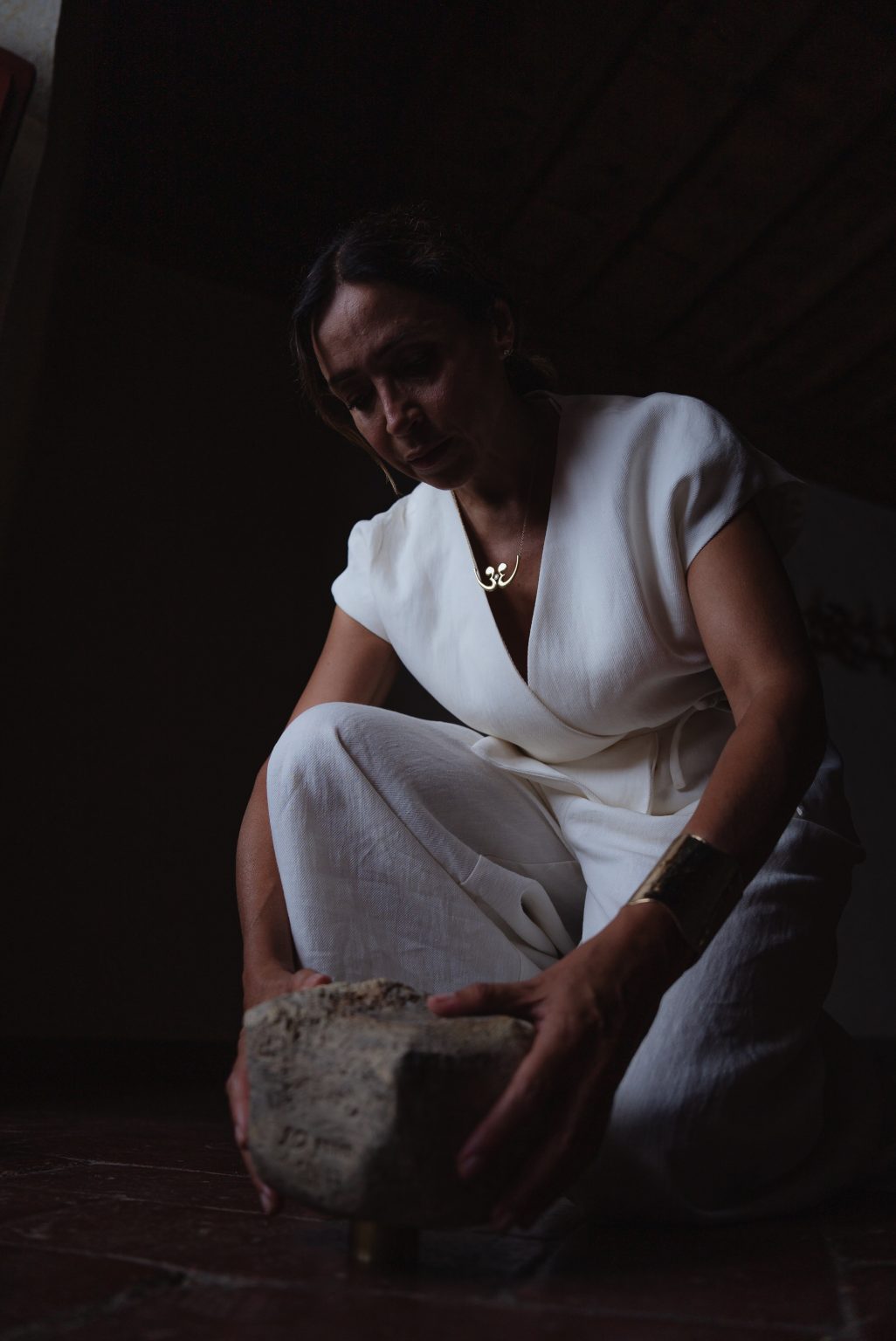 Portal of Memory performance, Villa Ferdinanda: performer in white crouching over a stone