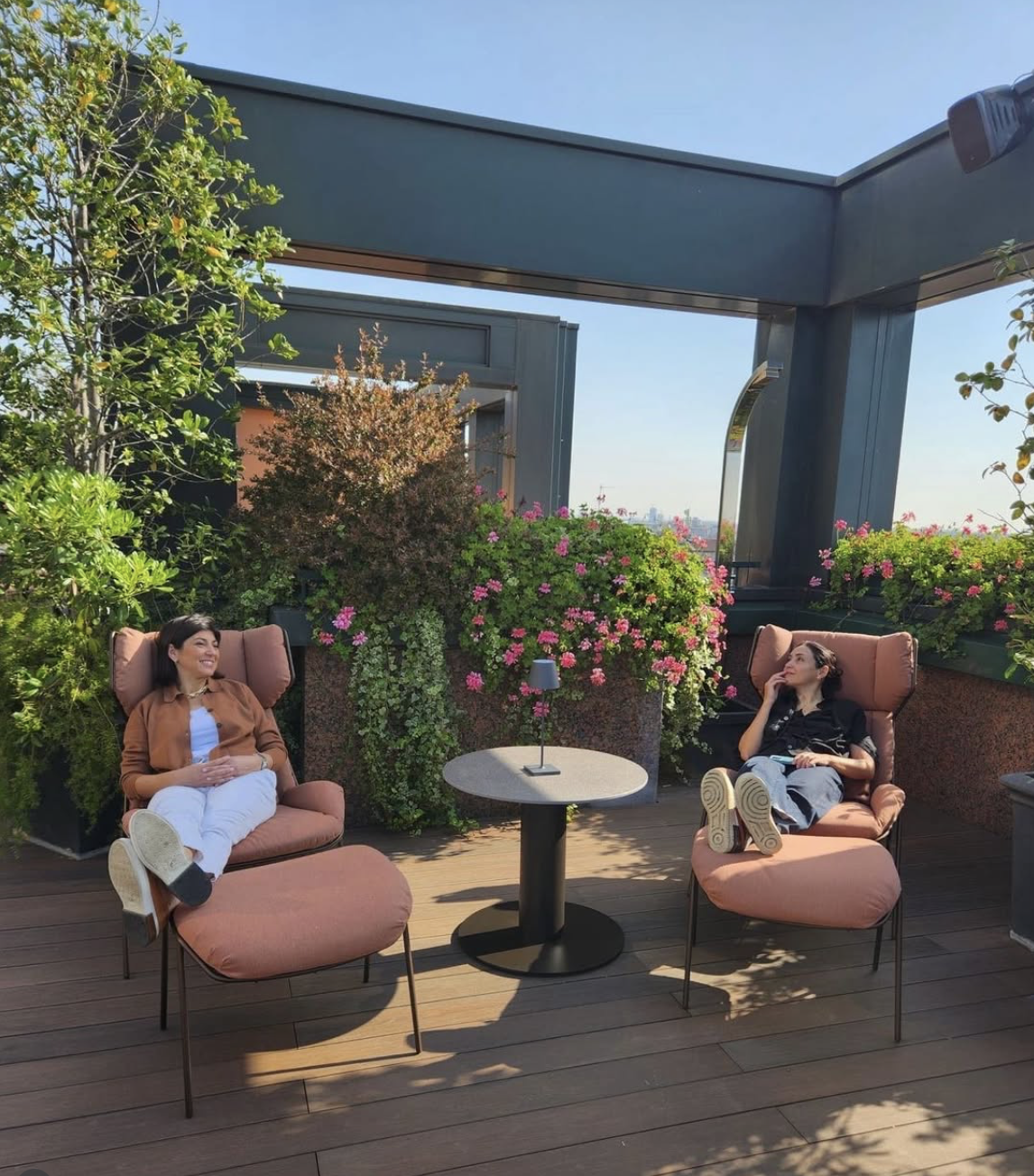 Terrace design for Westin Palace Milano: two guests relaxing in armchairs among plants on the terrace