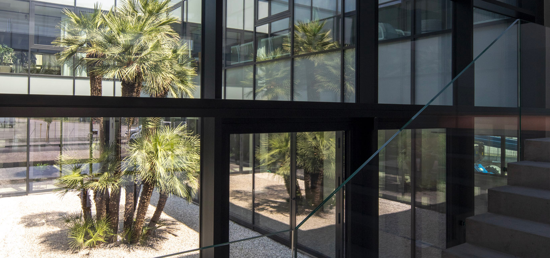 Atmosphera headquarters: glazed facade with palm trees reflected