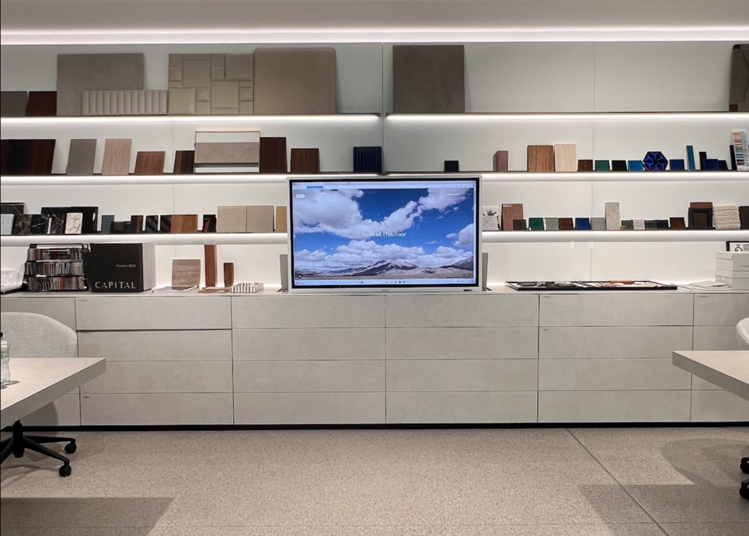 Atmosphera headquarters: office wall of white shelving with material samples and a screen