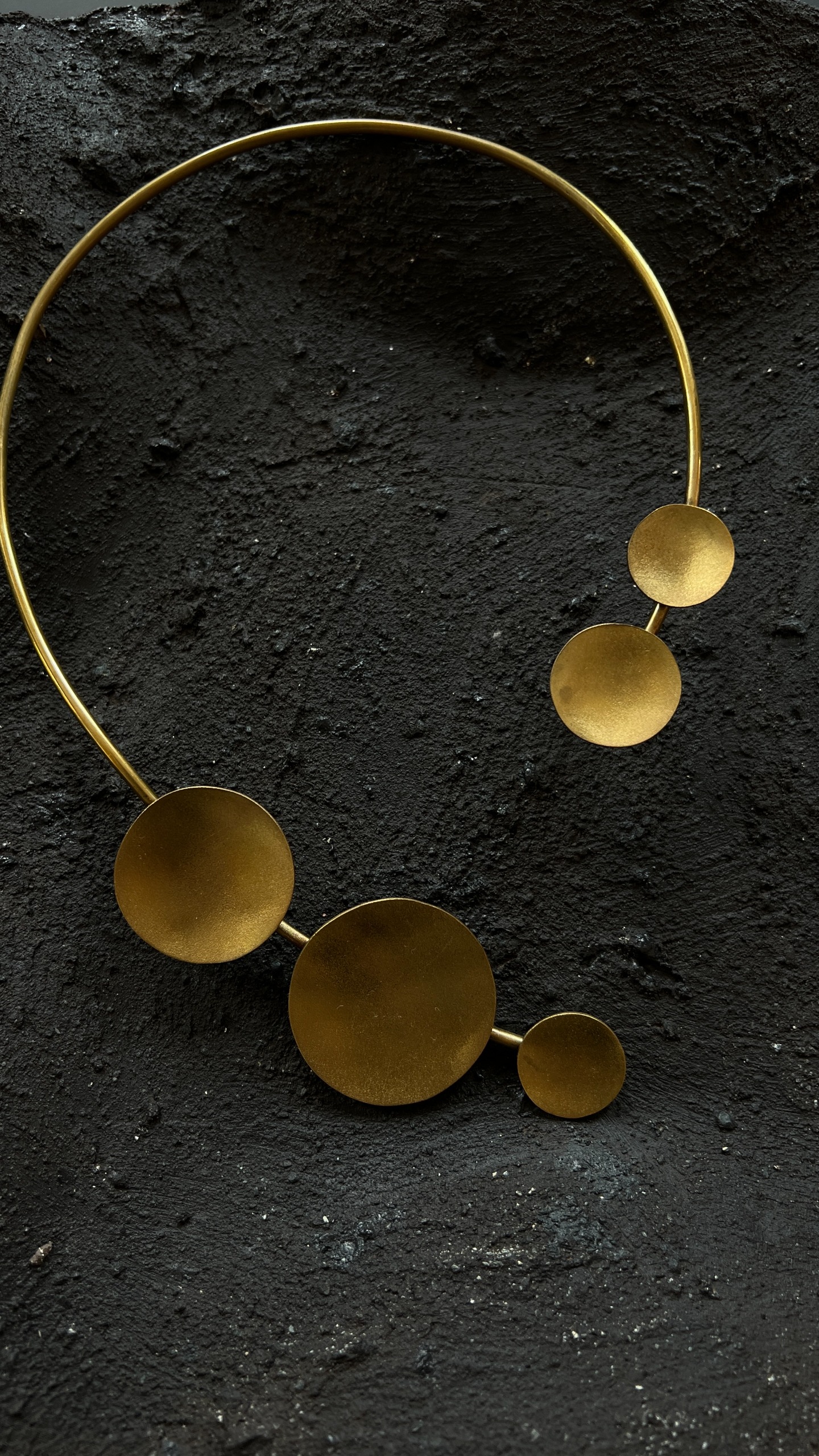 Collana Cassiopea di Elena Pelosi in ottone con dischi dorati, su pietra scura