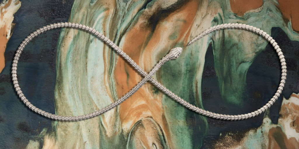 Collana Bvlgari Serpenti che forma un anello infinito su una lastra in ceramica marmorizzata di Elena Pelosi, nei toni verde, terracotta e blu profondo