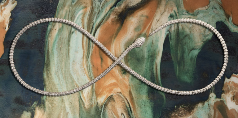 Bvlgari Serpenti necklace forming an infinity loop on a marbled ceramic slab by Elena Pelosi, in green, terracotta and deep blue.