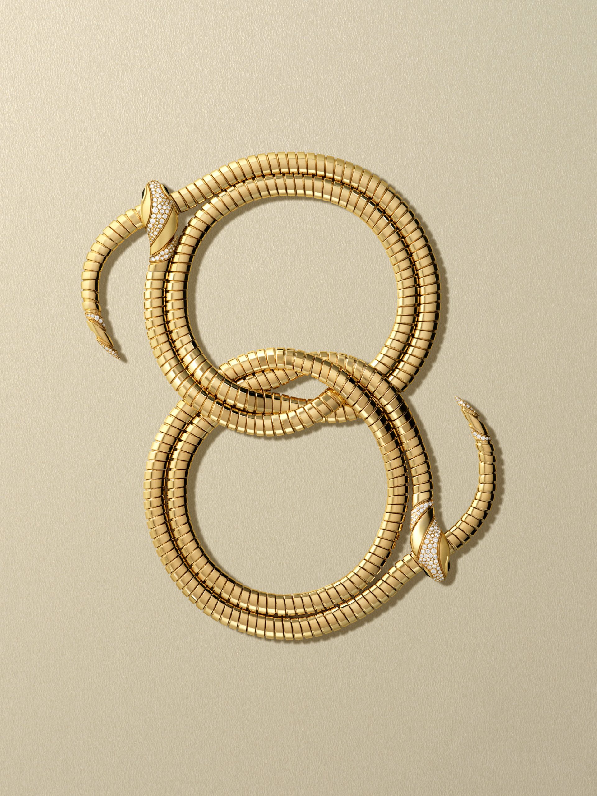 Bulgari Serpenti frames for Harper's Bazaar: two coiled Serpenti bracelets on a beige ground