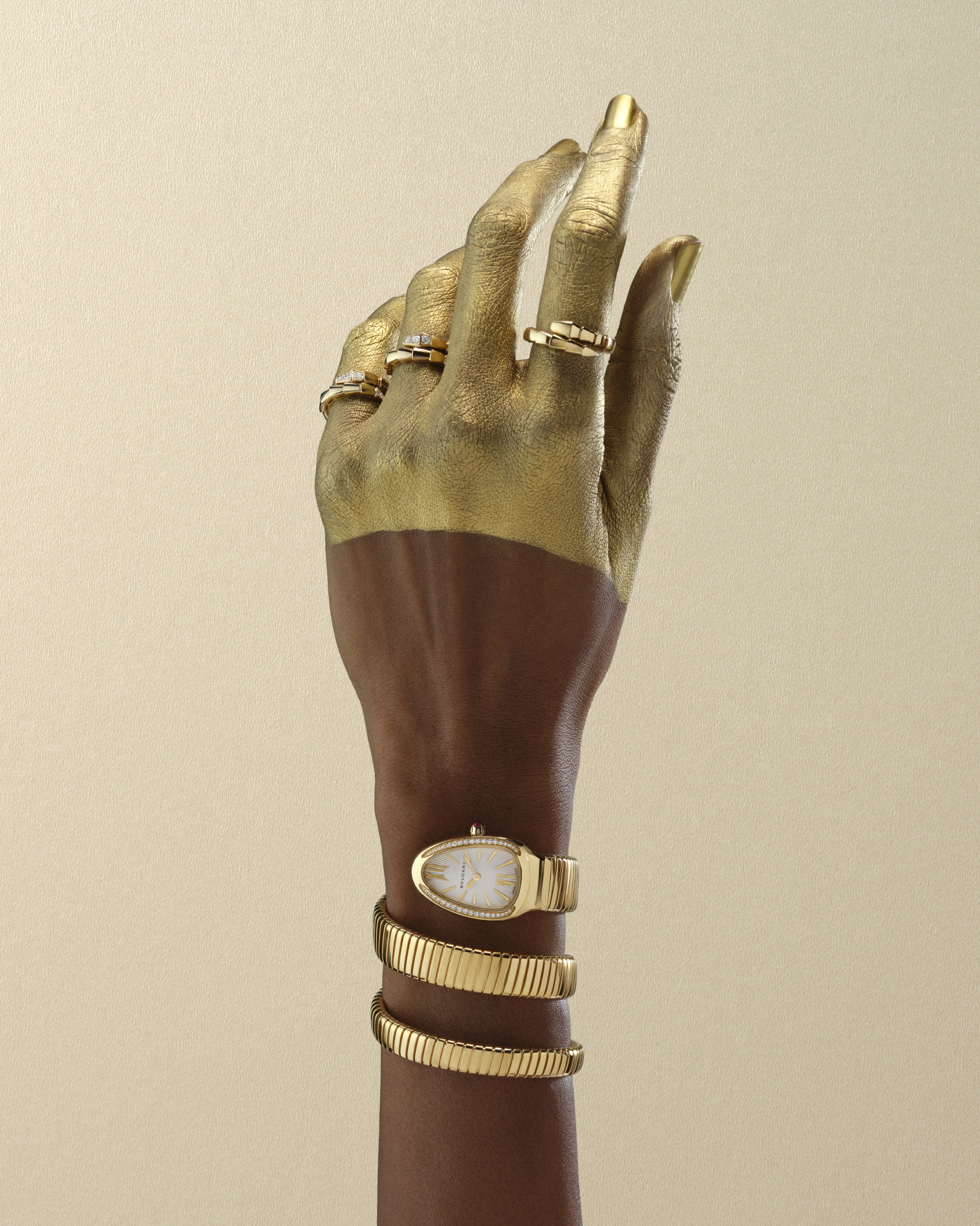 Bulgari Serpenti frames for Harper's Bazaar: gold-painted hand with a Serpenti watch coiled at the wrist