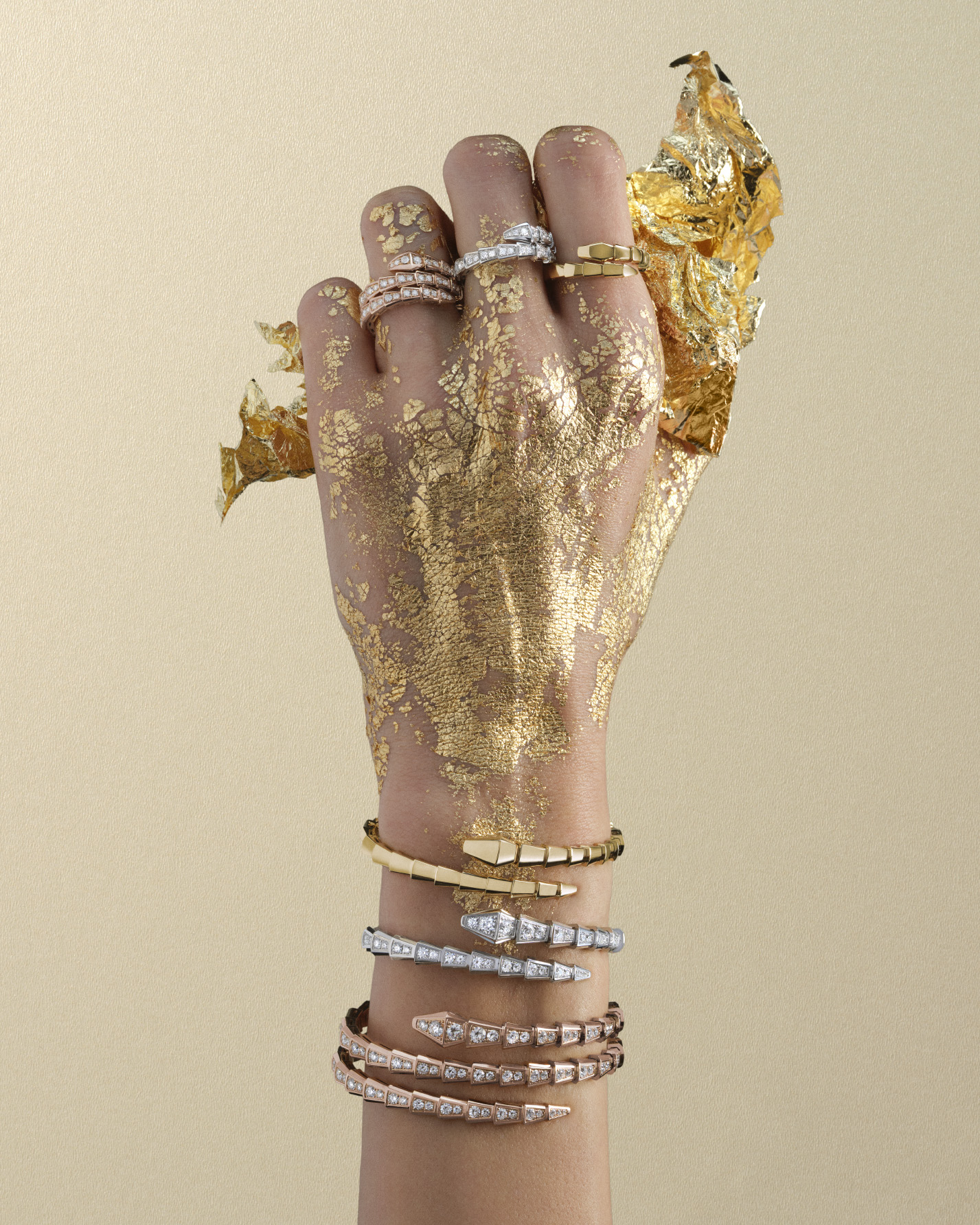 Bulgari Serpenti frames for Harper's Bazaar: gold-painted hand with stacked Serpenti bracelets and rings