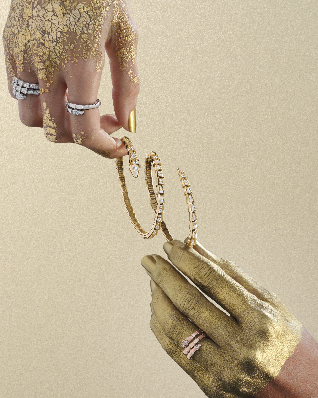 Bulgari Serpenti frames for Harper's Bazaar: gold-painted hands holding Serpenti bracelets