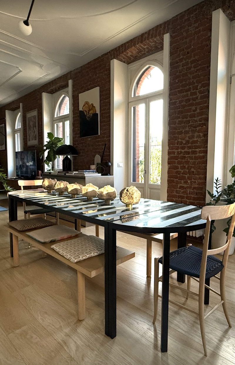 The Capri modular dining table, with a green and white striped marble top and black metal legs, in Elena Pelosi's dining room.