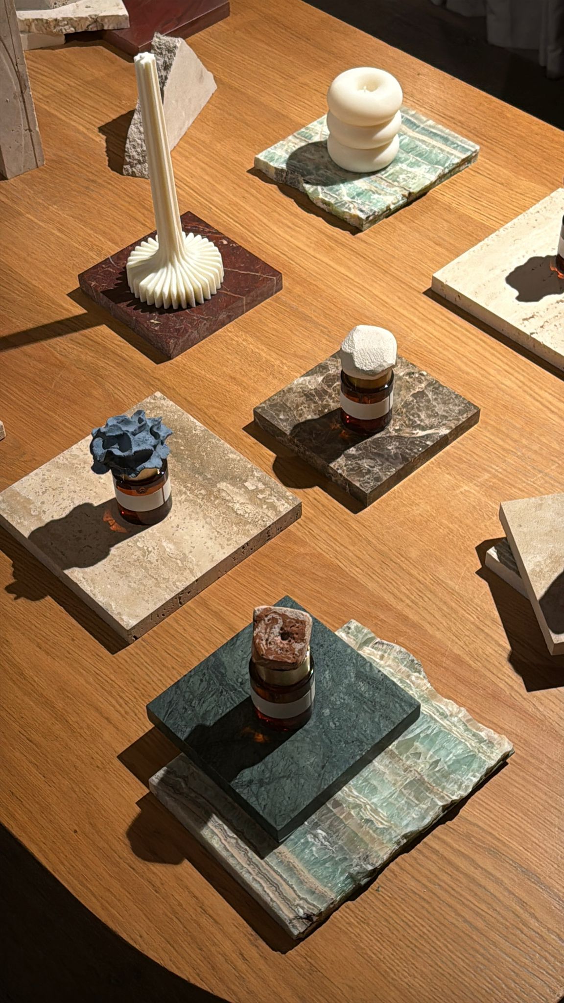 HABITARE event: objects and bottles arranged on marble squares on a wooden table