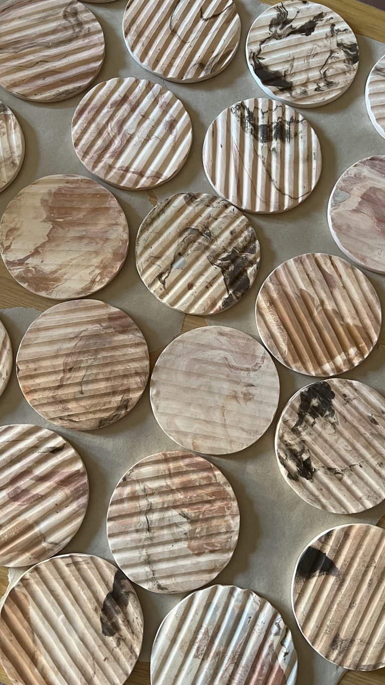 Rows of round ribbed ceramic pieces with a marbled glaze, made for the Cristofari pen holder gift set.