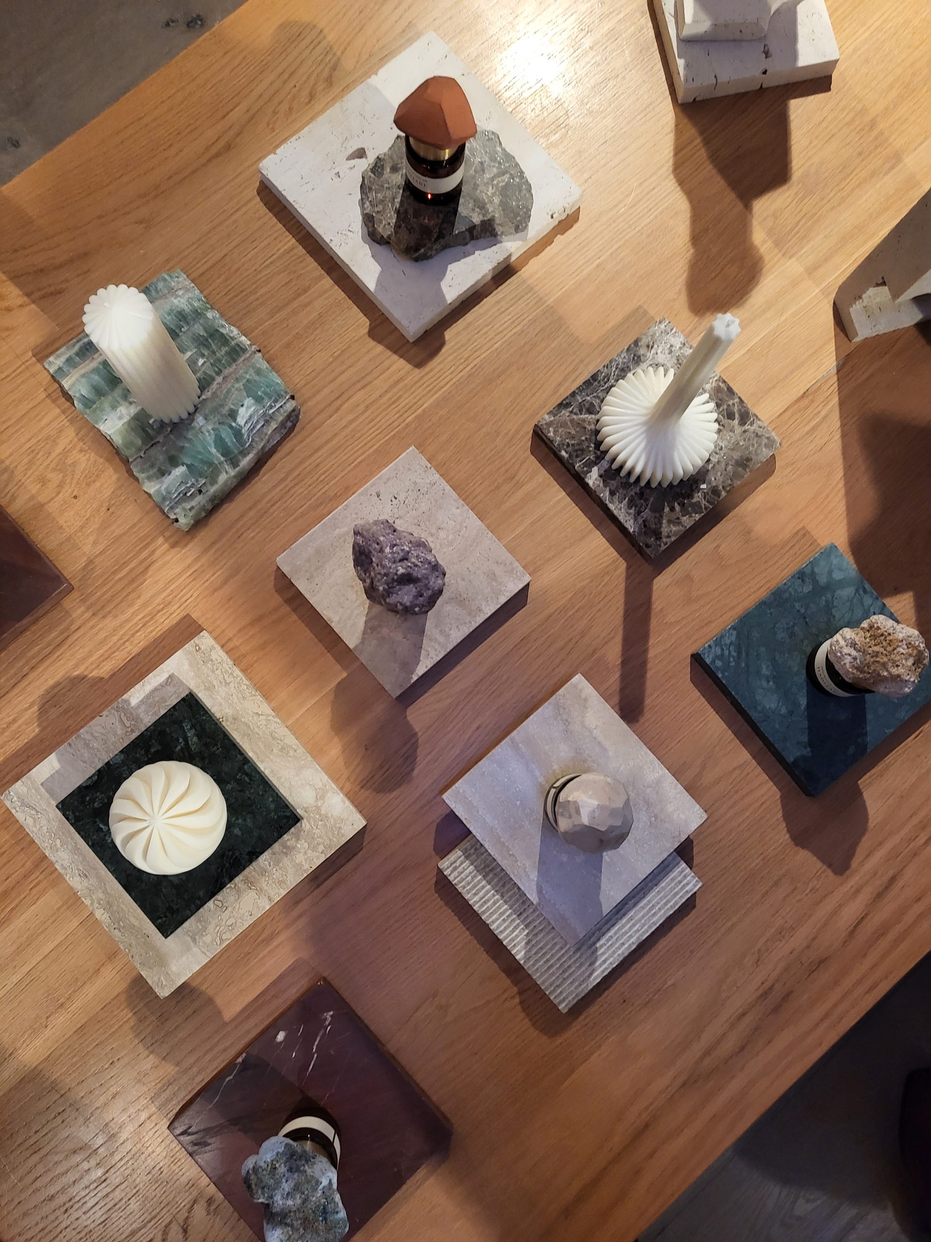 HABITARE event: table of marble tiles with stones, candles and fragrance bottles
