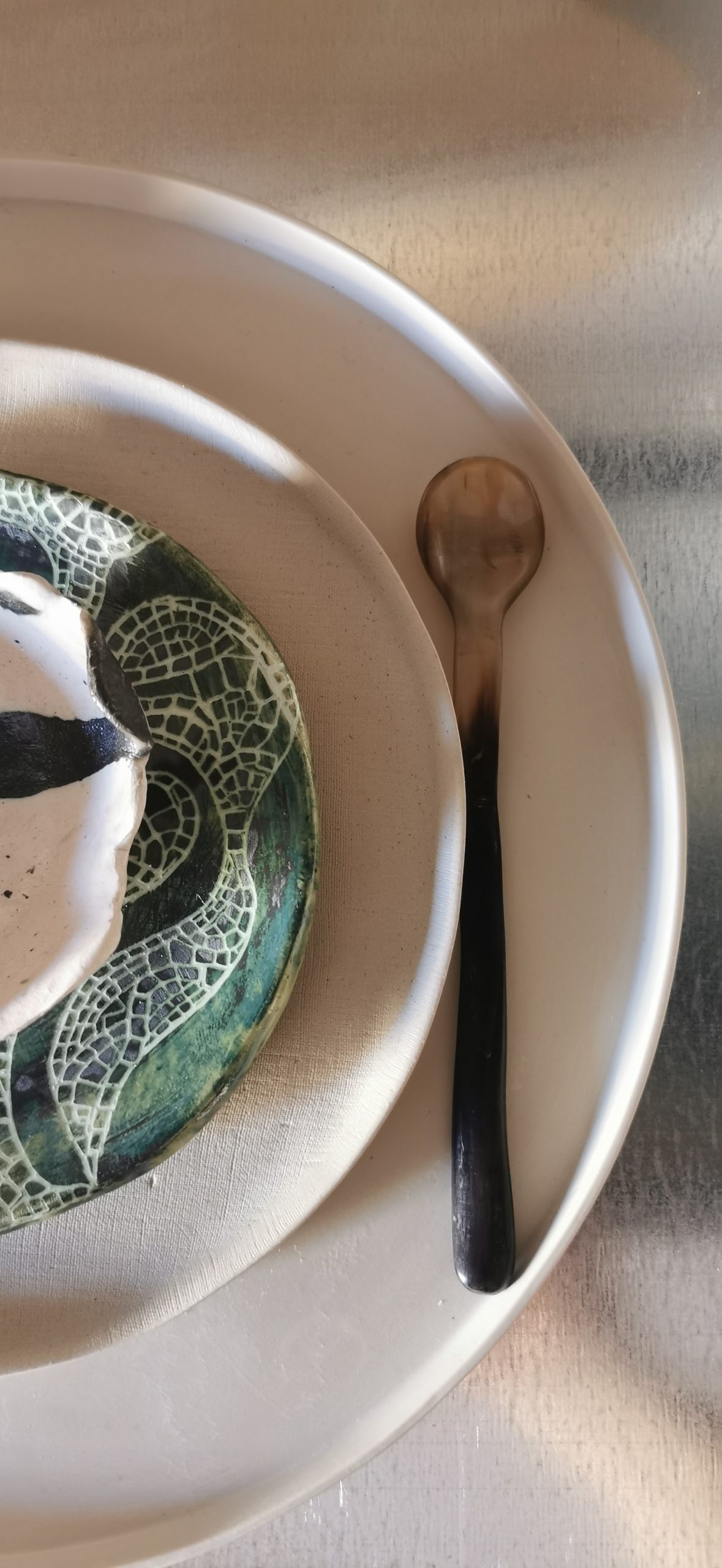Made in Fornace, The Dinner: green patterned ceramic plate with a dark spoon