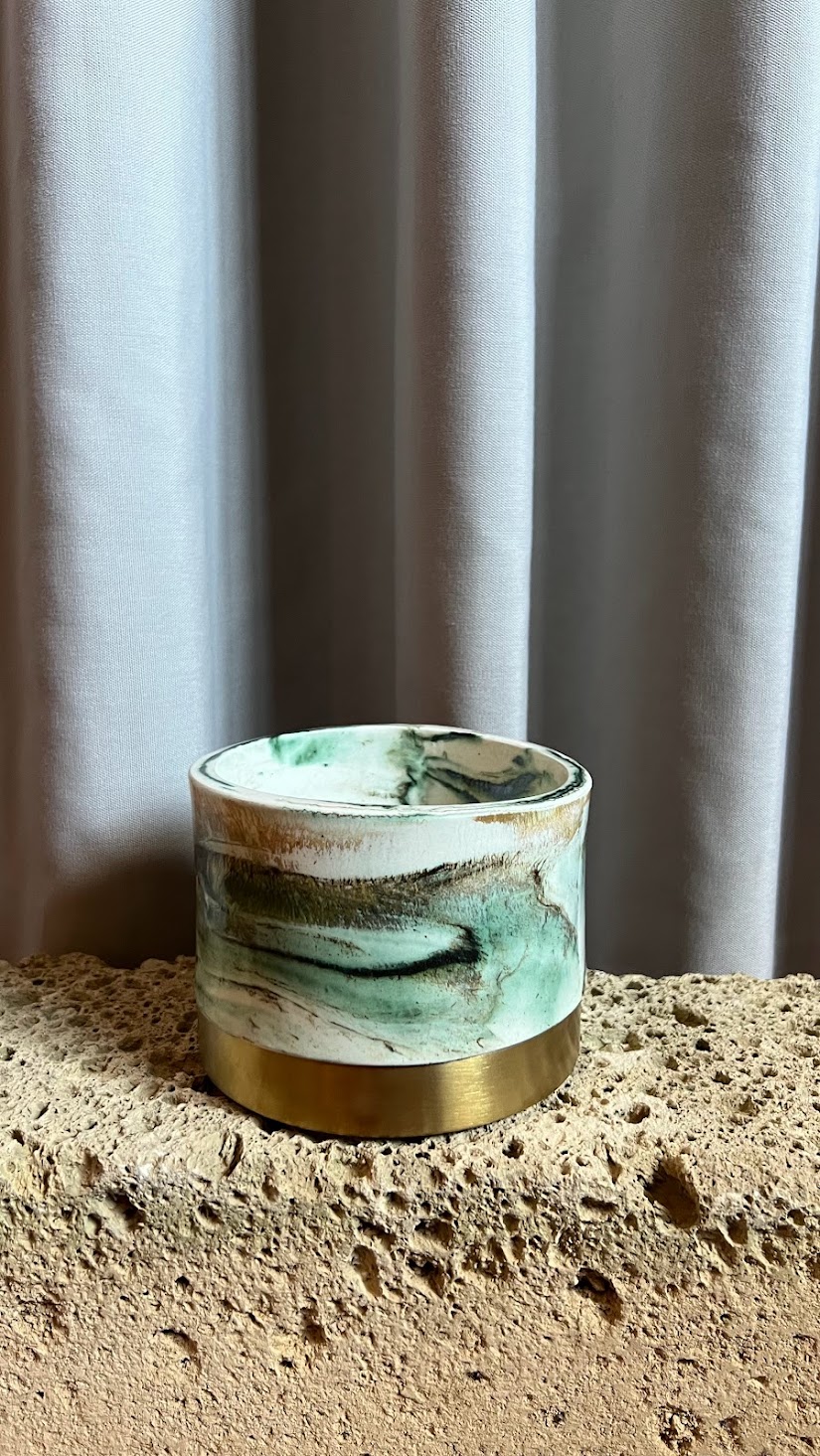 Panta Rei vase collection: green marbled vessel on porous stone before a curtain