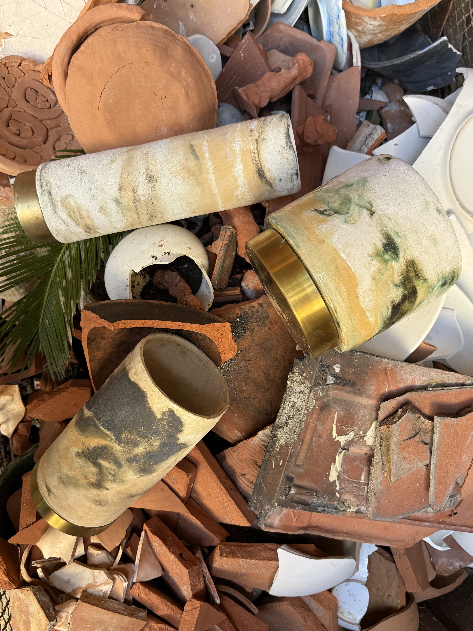 Panta Rei vase collection: marbled ceramic vases with brass bases among terracotta shards