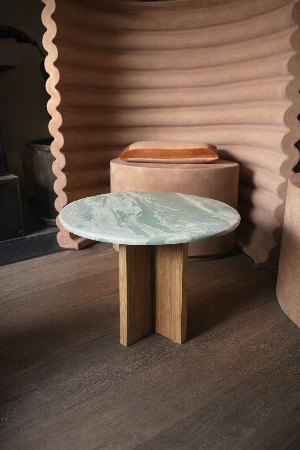 Panta Rei tables: round ceramic-top side table before a ribbed terracotta screen