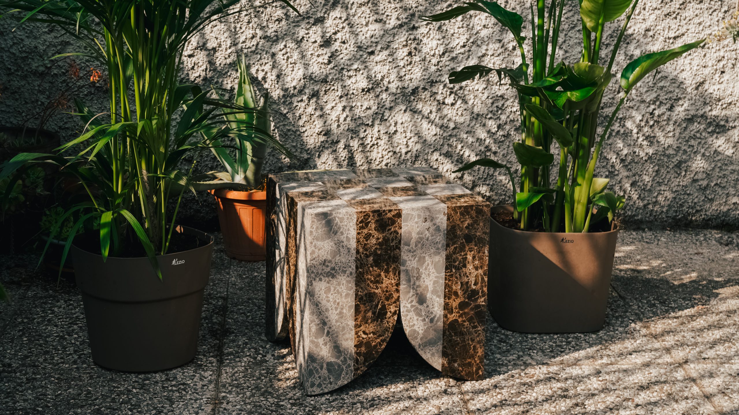 Atlas collection: brown and cream marble side table among potted plants