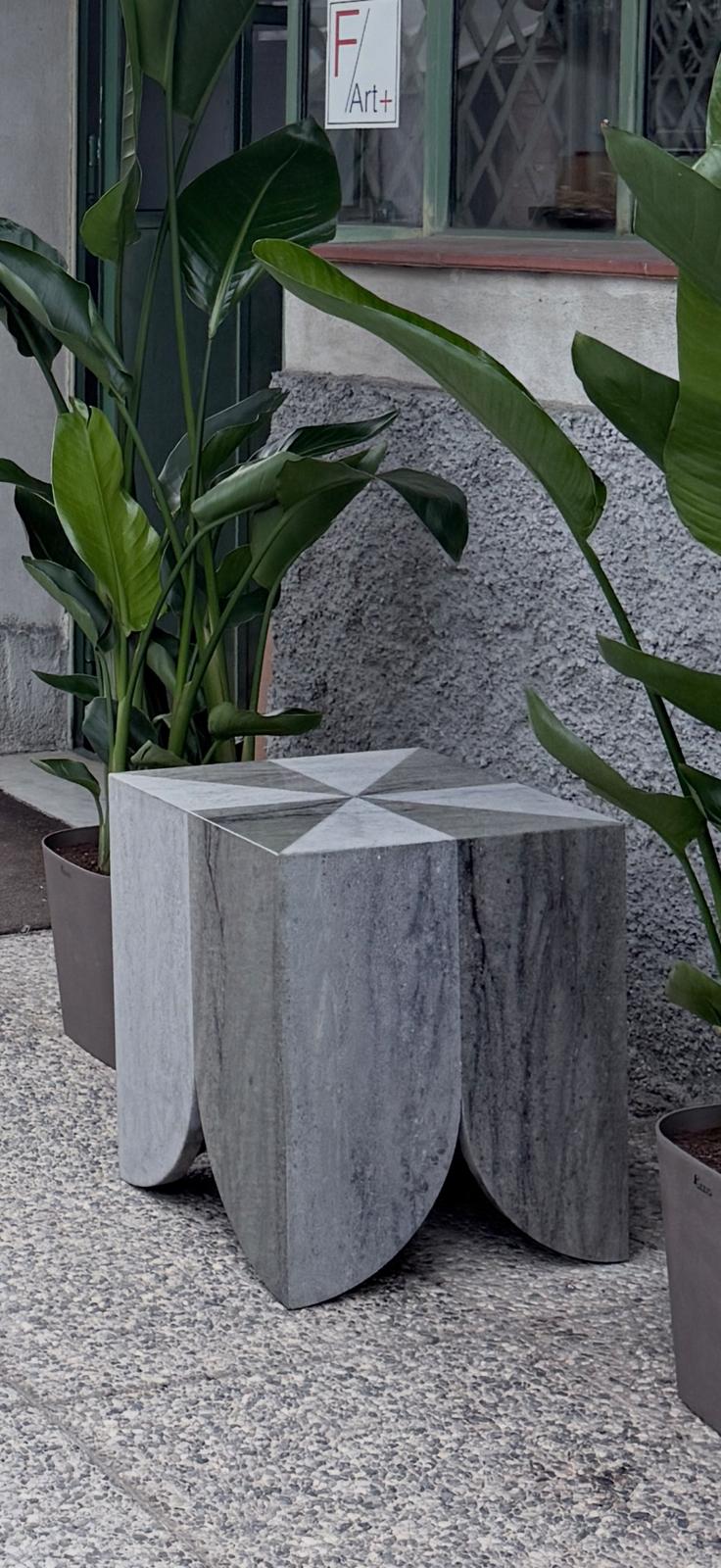 Atlas collection: grey marble side table among plants on gravel