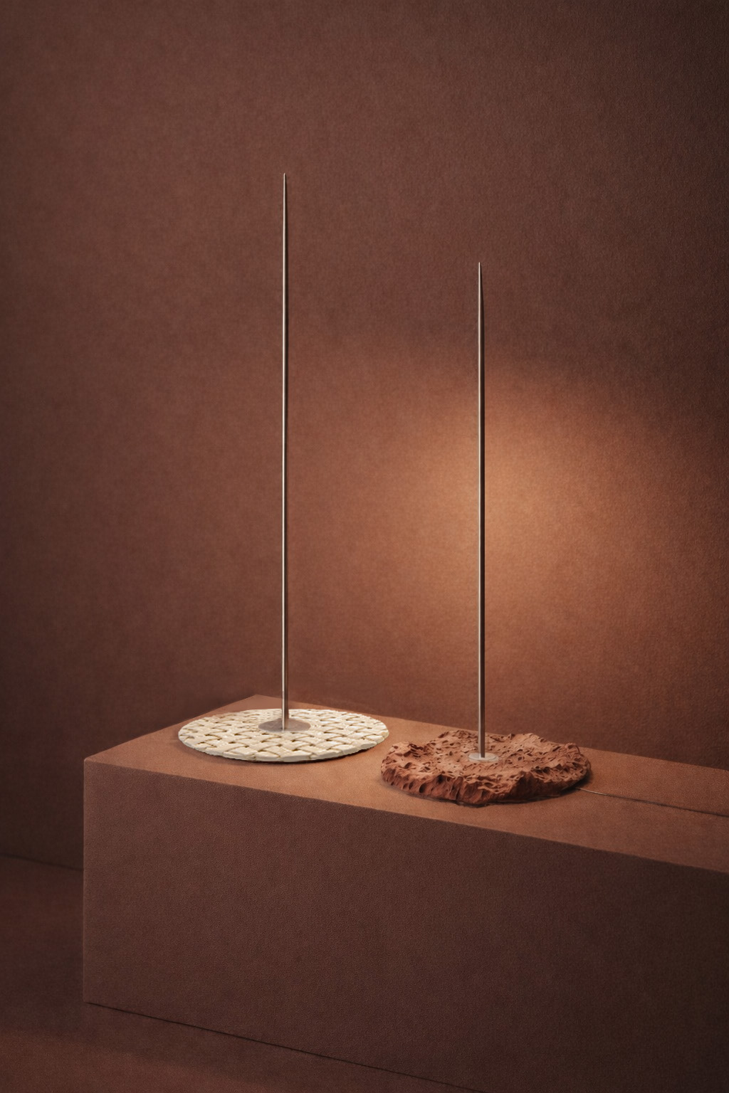 FATA lamp special edition: two slender lamps with woven bases on a plinth