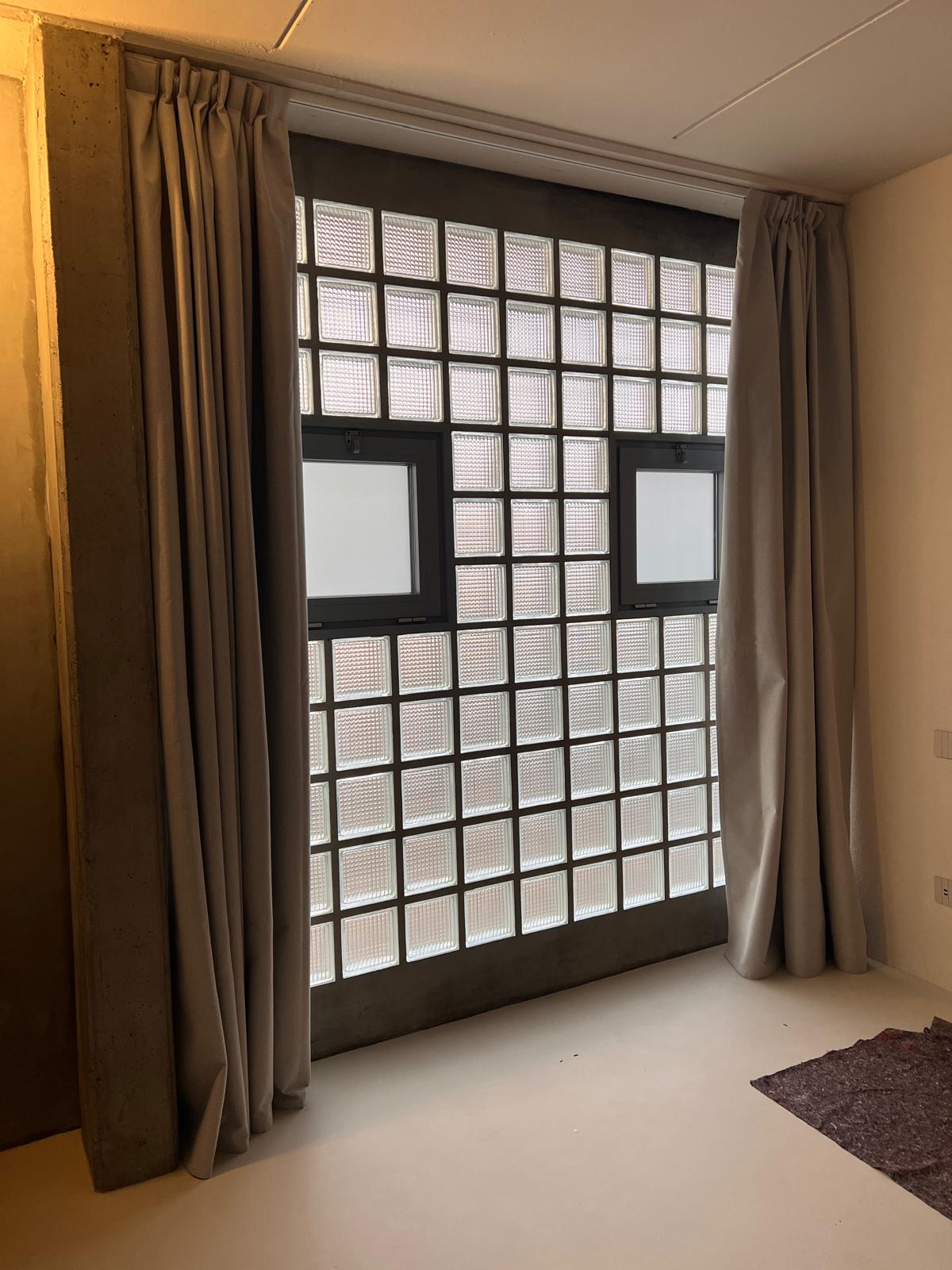 The Brutalist Grid: glass block wall with curtains in a bedroom