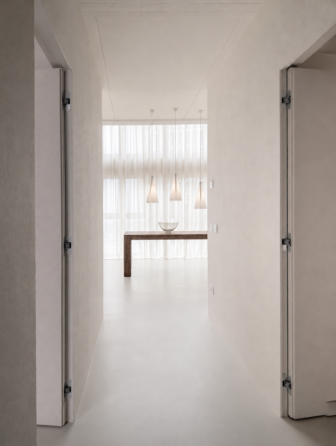 The Brutalist Grid: white corridor leading to a curtained room with a long table