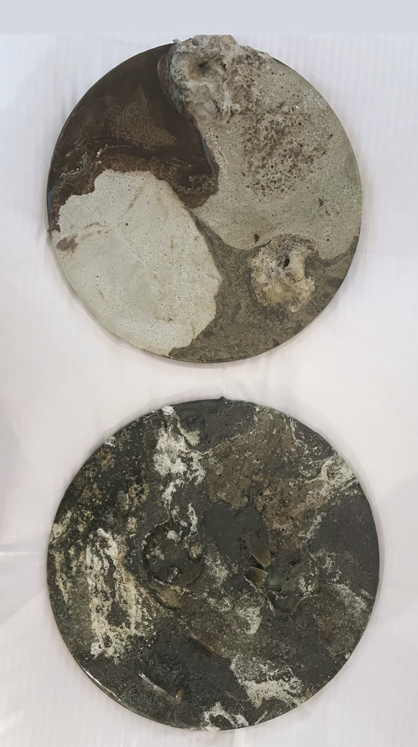 Heterogeneous clays research: two round fired panels with marbled mineral surfaces